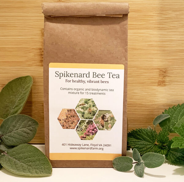 Bag of bee tea surrounded by herbs