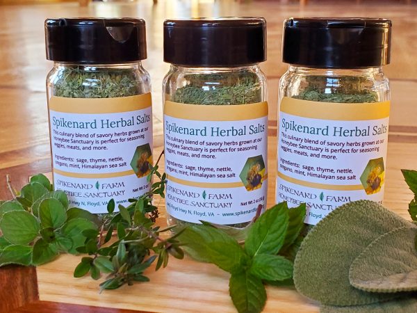 3 jars of Spikenard Herb Salt photographed with with fresh herbs.