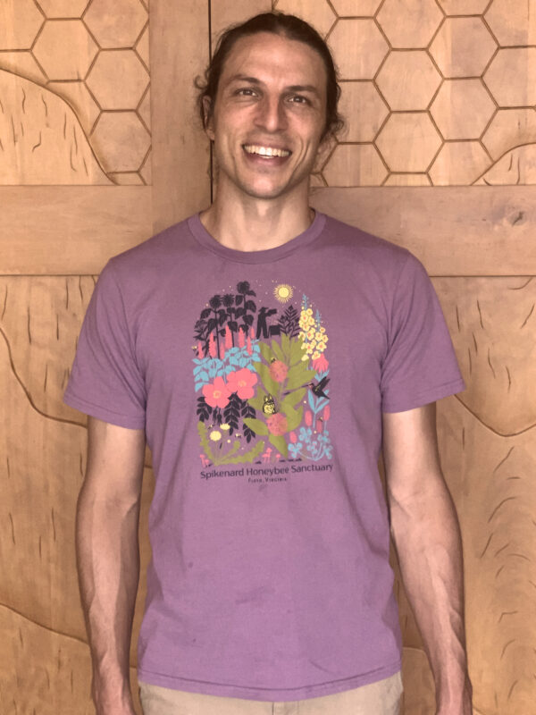 Alex modeling our new eggplant colored t-shirt with a five color design depicting various flowers, a beekeeper, a hive, several native plants, a hummingbird, butterfly and bees.